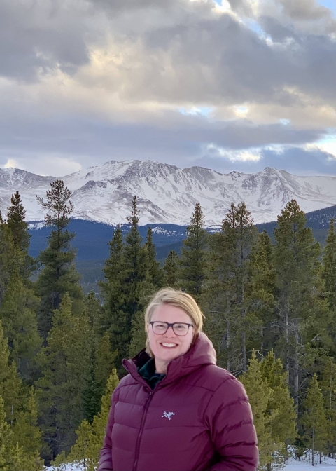 Nicole Alt with trees and mountains in the background