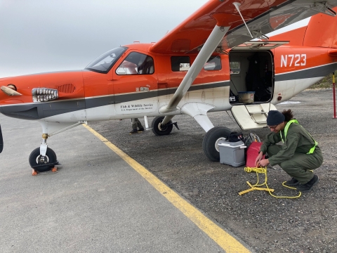 person kneeling next to an airplane