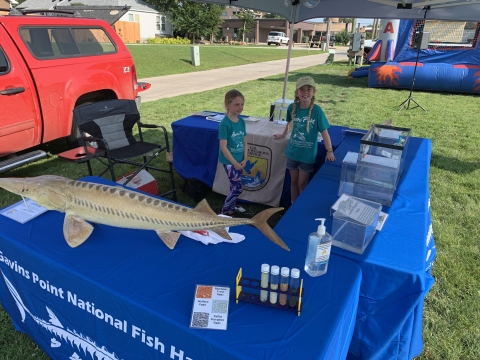 Two young girls beside an outdoor outreach exhibit