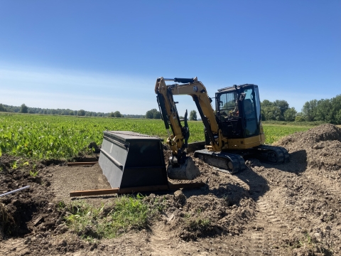 A backhoe works in a field of wapato.