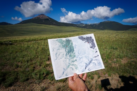 hand holding a before and after image against the landscape backdrop