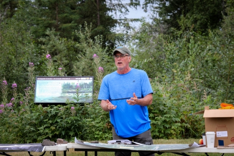 Mitch Osborne gives a presentation to partners and USFWS employees in front of a Cripple Creek interpretive sign in Fairbanks.