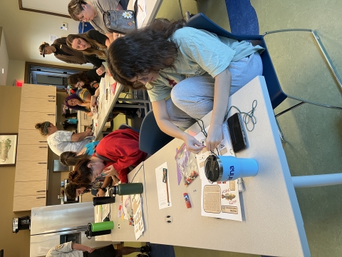 A group of people at tables working on a craft project.