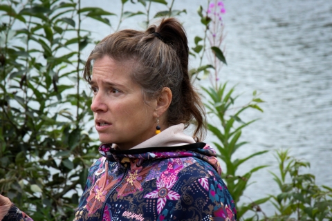 Holly Carroll speaks to a group gathered at Cripple Creek, in front of the Chena River.