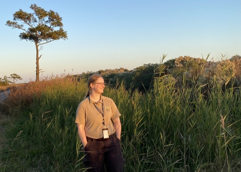 A woman alongside tall grass.