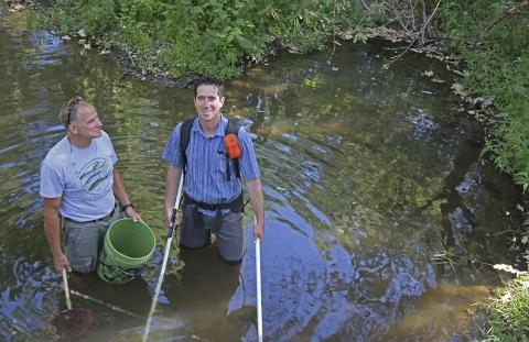 two men standing in a river