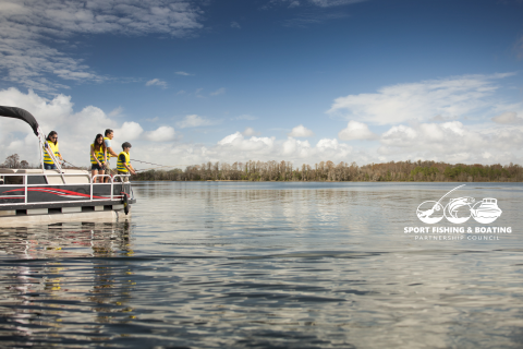 A family fishes off the side of their boat