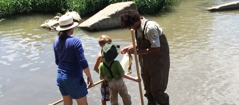 USFWS staff showing kicknet sample to children.