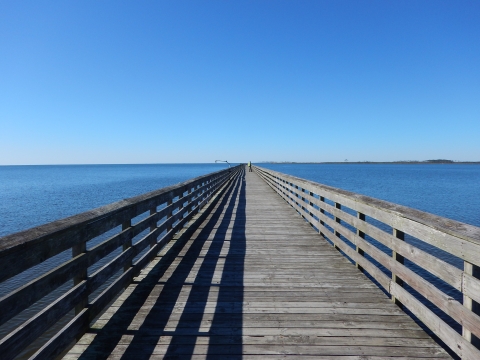 A plank fishing pier stretches into the distance