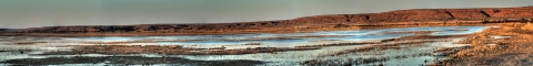 Panorama displaying the waters and brown hills at Bitter Lake National Wildlife Refuge.