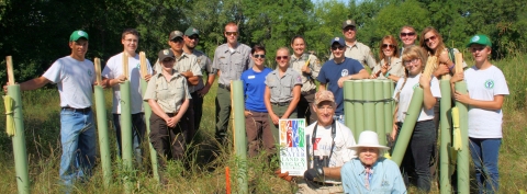 Friends of the Refuge Headwaters holding tree tubes outside.