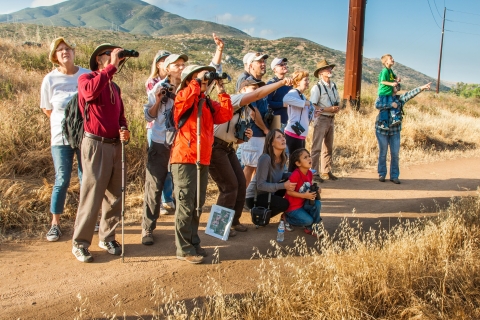 Visitors to San Diego National Wildlife Refuge point and react to a wildlife sighting on a ranger-led hike.