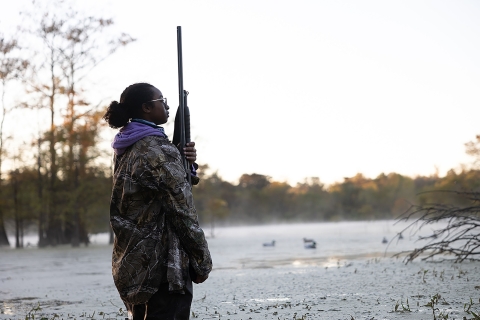 Young Woman In Hunting Gear Stands at Dusk-Wetlands