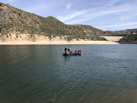 A boat can be seen on the reservoir with mountains in the background. 