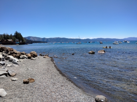 Shoreline of Lake Tahoe with boats in the distance.