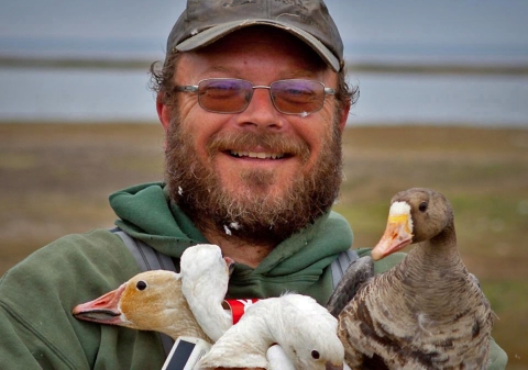 man holding geese