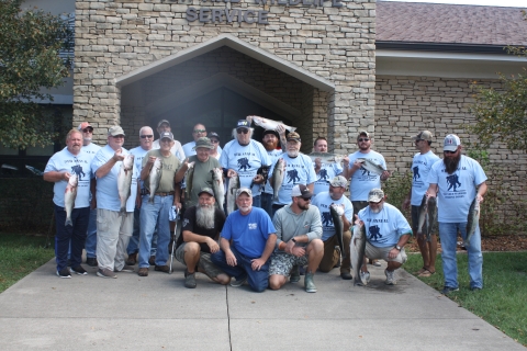 Wounded Warrior Fishing Derby participants holding stripers caught during the event