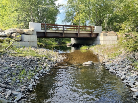 newly constructed bridge rests atop concrete blocks to cross the river 