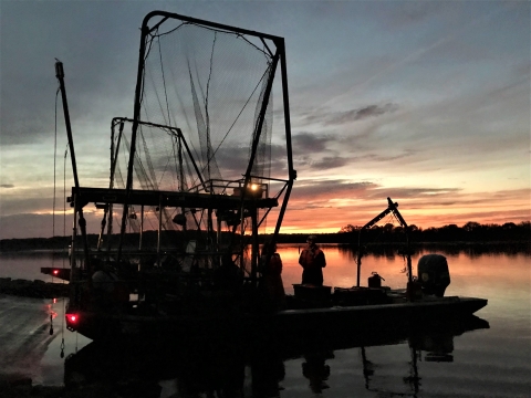 an electrified trawl net boat at sunset