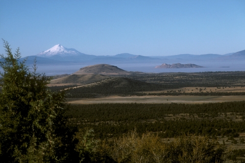 landscape of a plain with a snow capped mountain in the background