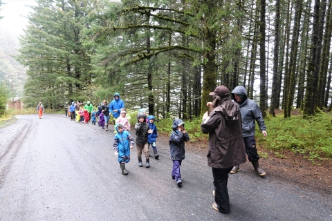 kids walking in a line down a road