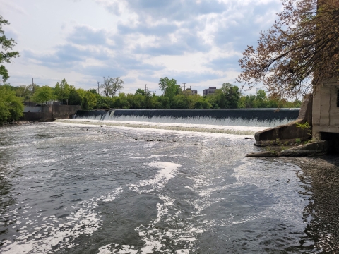 A majestic dam standing tall amidst a serene landscape, with water cascading down its walls.