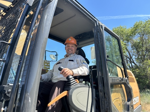 Robert Luna sitting in a dirt moving machine at Toppenish National Wildlife Refuge.