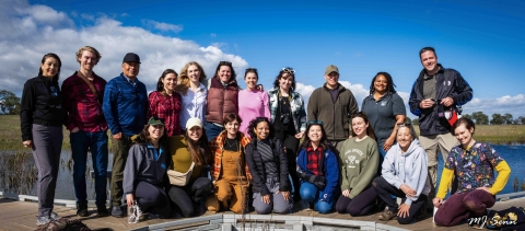 a group of people pose for a photo outside