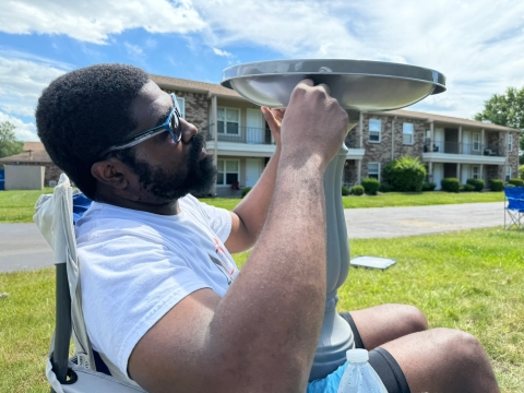 A man assembles a pollinator garden birdbath