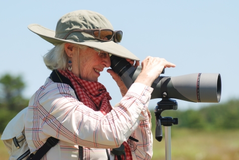 woman looks through a spotting scope