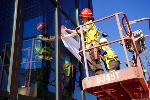 Rocky Mountain Arsenal NWR Staff apply bird safe glass film on the Visitor Center at the refuge.