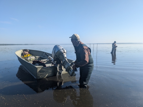 2 people and a boat standing in water