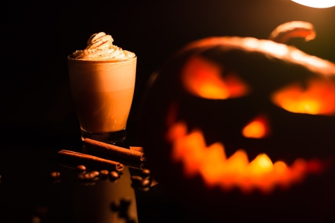 Pumpkin Spice latte next to a carved jack-o-lantern