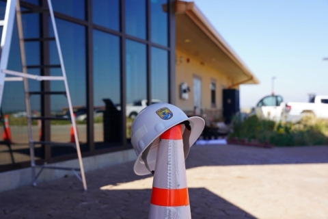 Foreground: USFWS Branded Helmet atop Hazard Cone. Background: Visitor Center of Rocky Mountain Arsenal National Wildlife Refuge