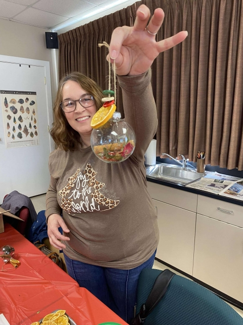 Woman holding handmade ornament in front of camera