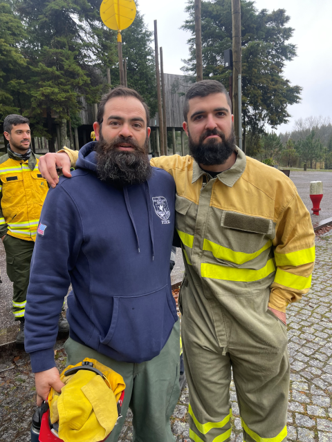 Dos bomberos forestales están abrazados frente a la cámara para tomar una foto.