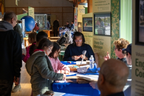 Children standing at a table doing arts and crafts.