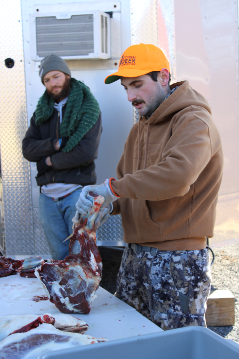 Mentor Matt (R) shows participants how to process harvested meat as Mentee Sam (L) watches on as part of the Field to Fork mentored rifle deer hunt at Cherry Valley National Wildlife Refuge in December 2024