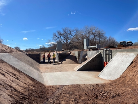 Three staff members stand in a construction area