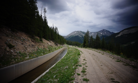 A ditch filled with water near a path in the mountains