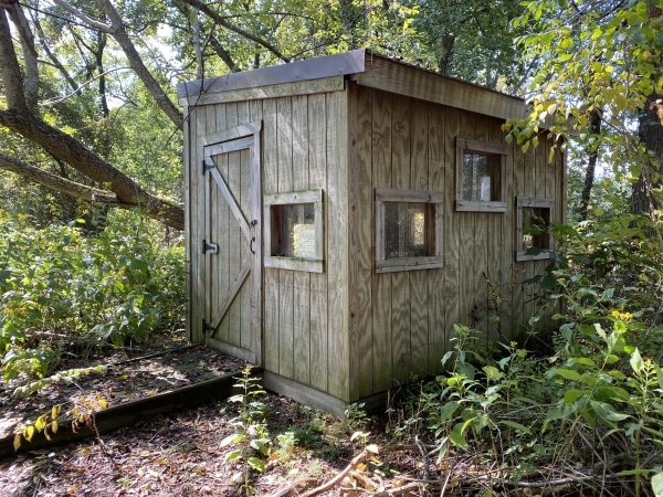 wooden photography blind in a forest