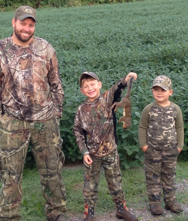 An image of an adult and two children hunting.