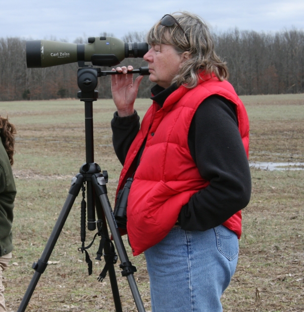 An image of a person looking through a spotting scope. 