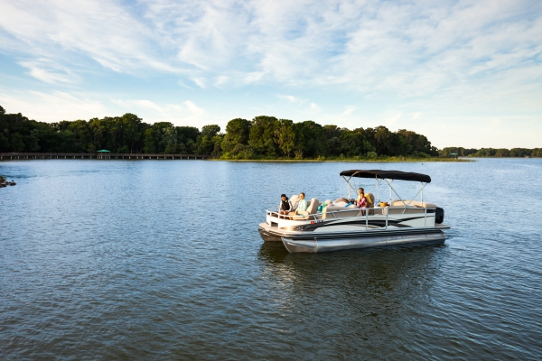 A family sits on a boat in a lake