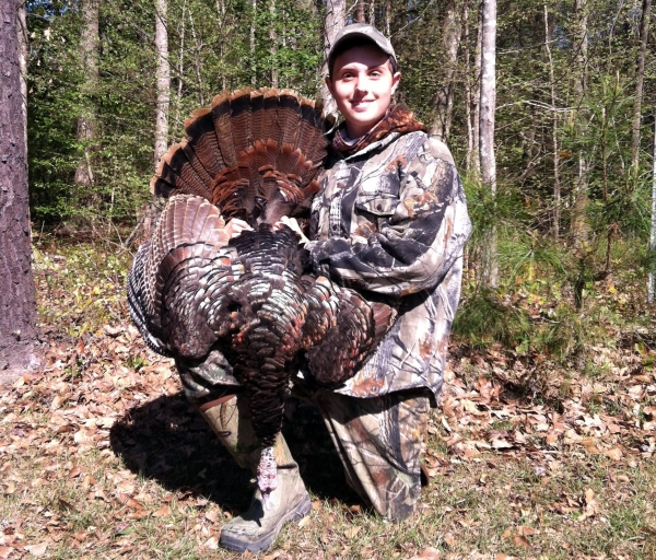 Youth hunter holding harvested turkey