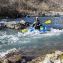 a man kayaks down a river in rapids