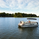 A family sits on a boat in a lake