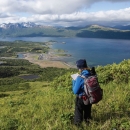 woman standing on hill overlooking view of lake on refuge