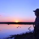 woman looking at lake at sunset