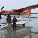 2 people standing in front of an airplane